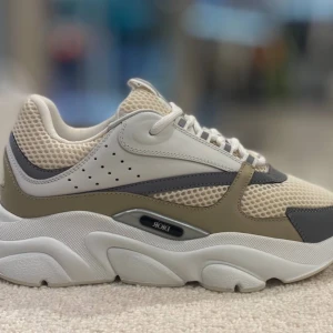 Beigeaa Dior b22 - Snygga beige sneakers från Dior med vit sula och grå detaljer. Skorna har en modern design med perforerade partier och snörning. Perfekta för en stilren look. Fastpris kan gå ner vid snabbköp box kvitto allt ingår i köpet.