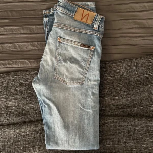 Ljusblå Nudie Grim Tims - Ljusblåa Nudie Grim Tims i felfritt skick! Storlek 29/32. Nypris runt 1500kr.