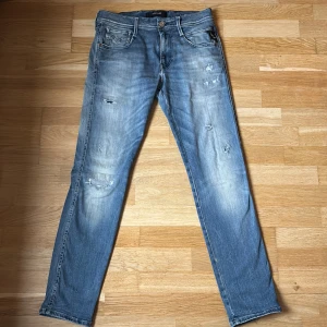 Blåa replay anbass hyperflex jeans - Tja! Jag säljer dessa snygga blåa replay anbass hyperflex jeans i storlek 30/30. Jeansen är i modellen slim fit och har en snygg wash med feta slitningar. Modellen på bilder är 178 lång. Skicket är 10/10, de är nya och helt oanvända och de har inga defekter eller skador. Hör av dig vid frågor eller om är intresserad!