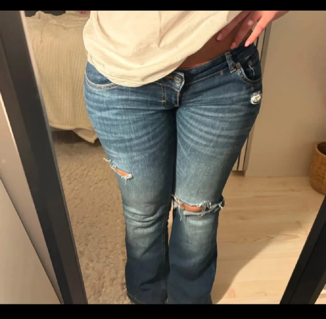 Blå bootcut jeans med slitningar