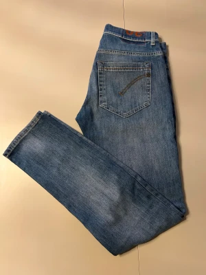 Skinny jeans från DonDup (george), blå - Snygga blå skinny jeans från DonDup George mall med klassisk femficksdesign och ljus tvätt. Jeansen har smal passform och är tillverkade i mjukt denimtyg med orangea sömmar och detaljer. Perfekt för dig som gillar en modern och slimmad look. Skick som nya, använda 1 gång!