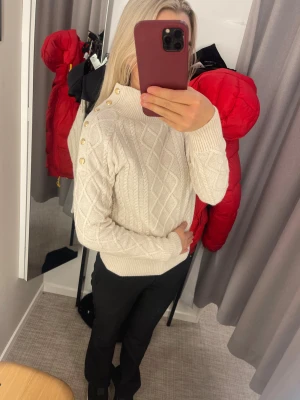 Vit stickad tröja med guldfärgade knappar - Säljer en helt ny jätte fin tröja med guldiga knappar vid ena axeln den är splitterny NY PRIS 699 kr 