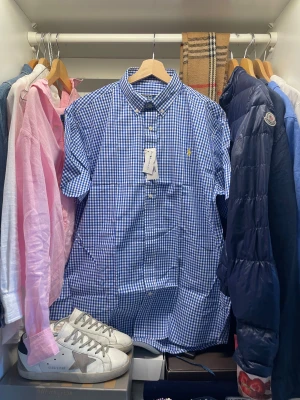 Blårutig skjorta Polo Ralph Lauren - Blårutig skjorta från Polo Ralph Lauren med klassisk button-down krage och vita knappar. Skjortan har gul broderad Polo-logot på bröstet perfekt stilren look till fina tillfällen. Nypris ligger runt 1500, skjortan är aldrig använd och har pristagarna kvar.                                                         Skriv vid frågor, priset är inte hugget i sten🤝  