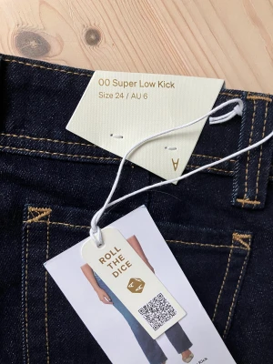 Mörkblå Super Low Kick jeans strl 24 - Säljer ett par snygga mörkblåa jeans, super low kick i storlek 24❣️. De är alldeles för stora  för mig. Storleken är stora så tips att gå ner en storlek! Prislappar kvar, aldrig använda. Innebensmått : 80cm och midjemått, kant till kant : 35cm