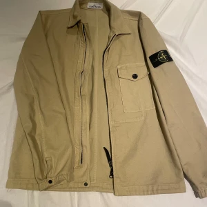 Beige overshirt från Stone Island  - Säljer en snygg beige overshirt från Stone Island storlek S. Skick 9,5/10 och den är perfekt för vår och höst! 