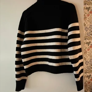 Svartvit randig polotröja S - Svart och vit polotröja från H&M med breda horisontella ränder. Tröjan har hög krage och långa ärmar, samt ribbade muddar vid ärmslut och nederkant. Perfekt för dig som gillar klassisk stil med en twist. Den är i storlek S och har aldrig använts, prislapp finns kvar💞