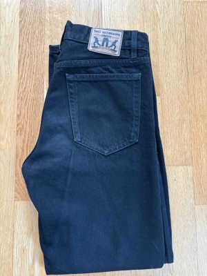 Svarta jeans från Sweet SKTBS - Säljer ett par svarta jeans från Sweet Skateboarding Company. Klassisk femficksmodell med raka ben och normal passform. Jeansen har en snygg svart tvätt, bälteshällor och patch med logga baktill. De är i storlek xx-small och passar nog personer mellan 165 och 175 cm. Inhandlade på junkyard för 700kr.