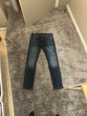 Replay jeans  - Säljer ett par snygga blå Replay jeans med klassisk femficksdesign och coola slitningar. Jeansen har normal i midja och är tillverkade i ett mjukt och stretchigt material. Priset är ej hugget i sten skriv vid frågor!! 