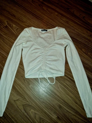 Vit croppad topp med snörning från Zara - Säljer en vit långärmad croppad topp från Zara 