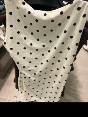 Vit prickig topp ifrån Zara - Snygg vit topp med svarta prickar och ärmlös design. Toppen är ifrån Zara, ny med prislapp kvar