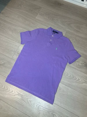 Ralph Lauren piké, lila, storlek M - Hej! Säljer nu denna lila Ralph Lauren pikén. Kortärmad samt storlek M. Inga skador eller fläckar. Riktigt stilren och snygg piké!  Skickar alltid inom 24h efter köp🤩 Frågor om mått eller annat? Hör av dig! 