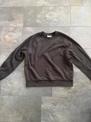 Svart sweatshirt från Calvin Klein XL - En stilren svart sweatshirt från Calvin Klein i storlek XL. Tröjan har rund halsringning, diskret Calvin Klein-logga på bröstet och är tillverkad i mjuk bomull. Perfekt för en clean och avslappnad look. Aldrig använd!!!!!