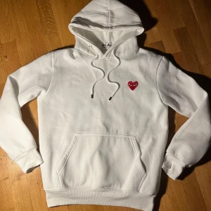 CDG Hoodie - Riktig fet och eftertraktad hoodie från CDG🤩. Passar till allt, och perfekt att ha i sin vardagliga stil💯. Strl L, men är lite små i storlekarna så skulle säga att den passar M bättre. Toppskick! Hör av dig om du har några frågor!