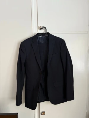 Svart kavaj med tillhörande kostymbyxor - Säljer nu min kavaj från H&M. Medföljer kavaj och tillhörande byxor. En klassisk och stilren kostym som passar för tillfällen där kostym är krävande.