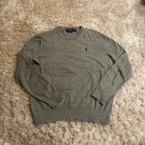 Grå tröja från Polo Ralph Lauren XS - Snygg grå tröja från Polo Ralph Lauren i mjuk pima bomull. Klassisk rund halsringning, långärmad och med diskret broderad logga på bröstet. Perfekt för dig som gillar stilrena och tidlösa plagg.