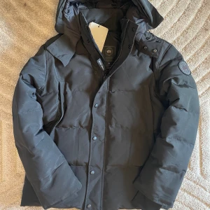 Canada Goose Jacka - Canada goose wyndham jacka helsvart me balcklabel. Den är storlek L passar också M håller värmen upp till minus 30 grader vattentät och detatchable päls. Helt ny med tagg skriv för mer bilder eller info.