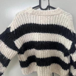 Randig stickad tröja från Zara - Säljer en grovstickad tröja från Zara i storlek 140. Tröjan har breda svarta och vita ränder, rund hals och lång ärm. Den är mjuk och har en loose passform som ger en chill vibe. Perfekt för dig som gillar klassiska mönster och vill ha något mysigt, perfekt för vintertider. Använd ett par gånger. 