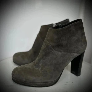 Grå mockastövletter Nyskick (a pair) - Snygga grå stövletter från a pair i mjuk mocka med rund tå och stabil hög klack. Snygga grå ankelboots från A Pair i nästan nyskick.   Köpta för ca 3500 kr.  Dragkedja på insidan. Klacken mäter ca 9,5 cm