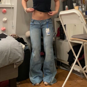 Lågmidjade bootcut jeans - Säljer dessa lågmidjade jeans. Jätte snygga men de är tyvärr alldeles för långa för mih. Lappen är kvar men jeansen är omsydda till bootcut. Midjemått 36 cm tvärs över midjan och innerbenslängd 81 cm.