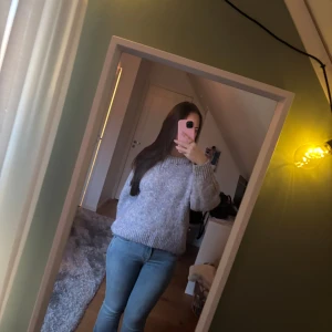 Ljuslila stickad tröja Vero Moda - Mysig stickad tröja från Vero Moda i ljuslila nyans med inslag av blått och vitt. Tröjan har en loose passform, ribbad rund hals och långa ärmar. Perfekt för att hålla sig varm under kyliga dagar. Snygg att matcha med allt.