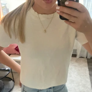  stickad t-shirt från zara - Säljer en stilren vit stickad t-shirt från Zara med rund hals och korta ärmar. Perfekt för dig som gillar minimalistisk design och mjuka material. Passar dig som vill ha en enkel men snygg look.