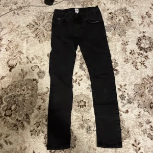 Svarta skinny jeans från BOSS XS - Svarta jeans från BOSS i storlek XS med skinny passform och klassisk femficksdesign. Snygga detaljer med BOSS-logga på bakfickan och läderpatch i midjan. Jeansen har en stilren look och är tillverkade i stretchigt bomullsmaterial.