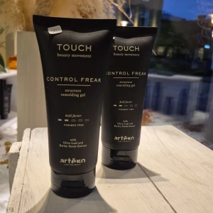 Artègo Touch Control Freak gel - Svart tub med guldig text, Artègo Touch Control Freak structure remolding gel. Innehåller olivblad och kornextrakt, fri från parabener. Snygg och stilren design, perfekt för dig som vill ha kontroll på frisyren.