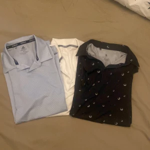 3 Adidas pikétröjor i olika färger - Säljer tre snygga pikétröjor från Adidas. En ljusblå med diskret mönster och logga på ärmen, en vit med grå ränder på ärmen och en svart med golfbollar som mönster. Alla har klassisk krage och korta ärmar, perfekta för sport eller chill. Materialet är mjukt och andas. Det står att storlekarna är xs men de passar både M och S, det är precis för små för mig som har L, säljer alla 3 för 400 eller 150kr st, kom gärna med frågor.