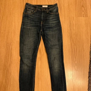 Mörkblå skinny jeans Tiger of Sweden - Snygga mörkblå skinny jeans från Tiger of Sweden med klassisk femficksdesign och kontrastsömmar. Högmidjade och tillverkade i stretchigt jeanstyg för en tight passform. Perfekt för dig som gillar stilrena och moderna jeans.