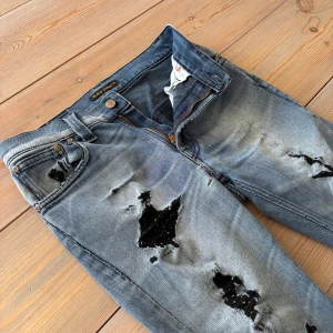 Blå slitna Nudie Jeans - snygg vitagelook🎞️ - Slitna jeans från Nudie jeans i strl 30/32. Slim/tajt fit, snygg sliten look - perfekt till dig som gillar en sliten look. Jeansen har igen sydda hål men det ändrar inte helhetsbilden. 🎩Unik look 💙Snygg blå färg🎯Just nu endast 399kr!🚚Passa på medans frakten är gratis!