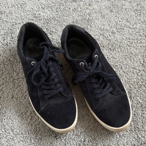 Svarta mockasneakers från Vagabond - Slitna svarta sneakers från Vagabond i mocka med klassisk design. Skorna har rund tå, snörning och vit platt sula som ger en clean look. 