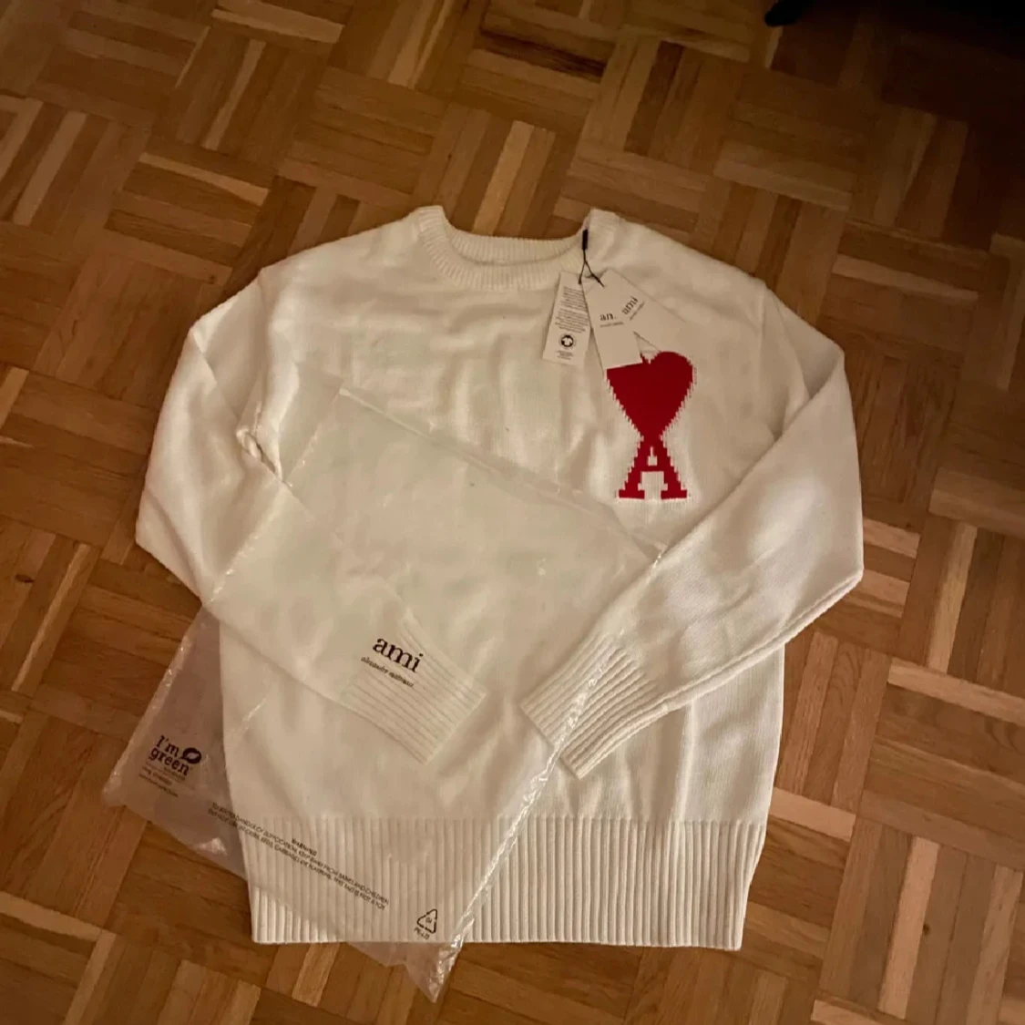 Vit stickad tröja med rött hjärta från Ami