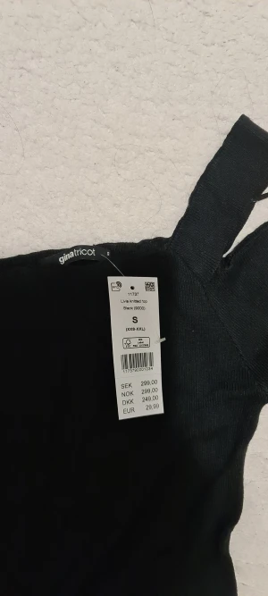 Svart stickad offshoulder topp Gina Tricot - Säljer en svart stickad topp från Gina Tricot i modellen Livia. Toppen har breda axelband och offshoulder-design med långa ärmar. Materialet är mjukt och stretchigt, perfekt för att skapa en cool och trendig look. Passformen är slim och toppen är enkel att matcha med dina favoritjeans.
