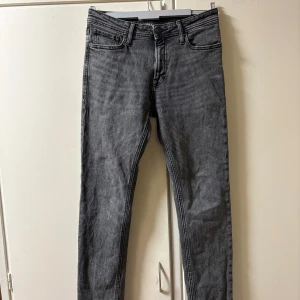 Jack & Jones Jeans - Snygga gråa jeans från Jack & Jones, modell Clark Regular. Endast använda ca 10 gånger. Nypris: 699kr, Skick 8,5/10. Perfekta för dig som gillar stilrena och tidlösa jeans. Passformen är enligt mig perfekt, slimmade men inte för tajta. Vid frågor är det bara att höra av sig.
