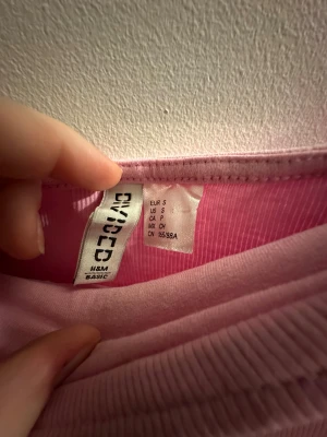 Rosa tubklänning från H&M Divided - Tubklänning i ljusrosa från H&M Divided, storlek S. Klänningen är kort och har en tight passform med ribbad struktur. Perfekt för dig som gillar enkel och stilren design med en feminin touch.