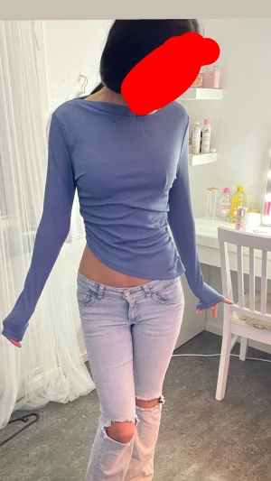 Blå ribbad långärmad topp från SHEIN - Säljer en blå långärmad topp från SHEIN i storlek S. Toppen är ribbad med en tight passform och har en snygg rynkning på ena sidan som ger en cool detalj. Materialet är mjukt och stretchigt, perfekt för dig som gillar en enkel men trendig look.