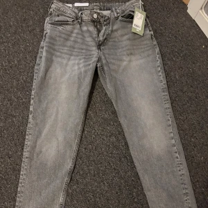 Grå tapered jeans från H&M - Snygga grå jeans från H&M i tapered modell med regular fit. Helt oanvända 