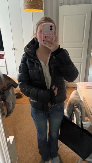 Svart Superdry med huva - Säljer en svart Superdry jack  med huva och quiltad design. Jackan har dragkedja framtill och en snygg, lite kortare passform som sitter bra över jeans. Perfekt för dig som gillar en clean och enkel stil under höst och vinter.