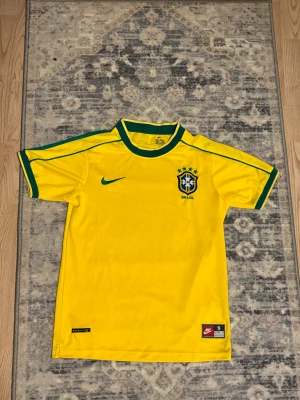 Brasilien fotbollströja - Snygg vintage brasilien fotbollströja i storlek S. Använd 1 gång. Nytt skick. Säljer för att det inte riktigt är min stil. Skriv för funderingar och pris kan diskuteras vid snabb affär.
