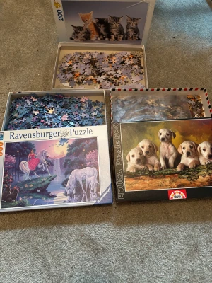 Tre olika pussel -  Tre olika pussel med motiv av kattungar, enhörningar och hundvalpar. Pusselbitarna är förpackade i sina respektive lådor.