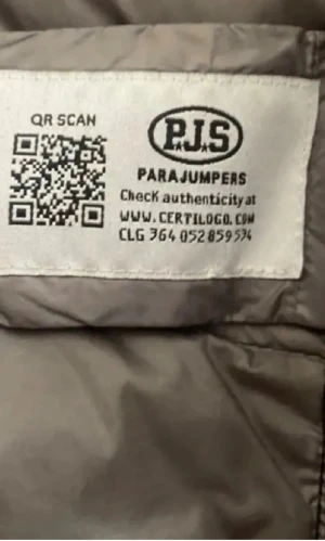 Svart pufferjacka från Parajumpers - Säljer en svart pufferjacka från Parajumpers med grått foder och coolt patch på ärmen. Jackan har dragkedja framtill, ståkrage och flera fickor med zip. Perfekt för dig som vill ha en lätt och snygg jacka med street vibe.Jackan har två luft hål under armhålorna.Dragkedjan saknar en grej och jackan har små hål (en vid axeln och en i den högra fickan).Men funkar jättebra och det går å fixa men jag har ingen lust för det.😊