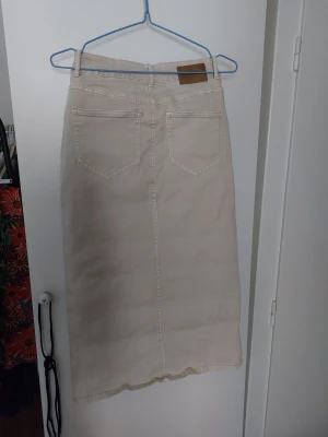 Beige jeanskjol från Red Button trol felmärkt. - Tror den är felmärkt för jag är 38 och kommer i den. Superstretchig kjol. Säljer en beige kjol från Red Button med klassisk jeanslook, fem fickor och slits framtill. Kjolen har bälteshällor och knappstängning i midjan. Perfekt för dig som gillar enkel och stilren design med denimkänsla.