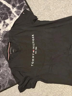 En Tommy hilfigher T-shirt - En Tommy hilfigher T-shirt som inte använts typ nånting, den kanske ser lite skrynklig ut men de är bara för den legat i garderoben!