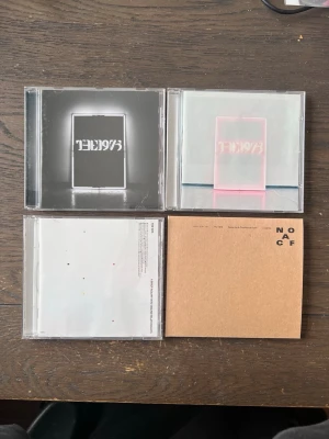 The 1975 cd-skivor samling - Fyra skivor av The 1975, deras fyra första, "1975", "I like it when you sleep, for you are so beautiful yet so unaware of it", "A Brief Inquiry Into Online Relationships" och "Notes On A Conditional Form". De är väl använda och fodralen har en del repor men alla skivor är i bra skick och spelbala. Ingår även en poster med små defekter (se bild)