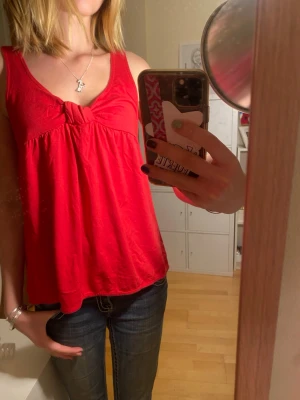 Jättefint rött linne från piper  - Coolt babydoll linne med knut. Så coolt linne men samtidigt basic. Modellen är superfin och tyget är skönt! Passar bra på mig och jag är storlek S ungefär men storleken är 10!