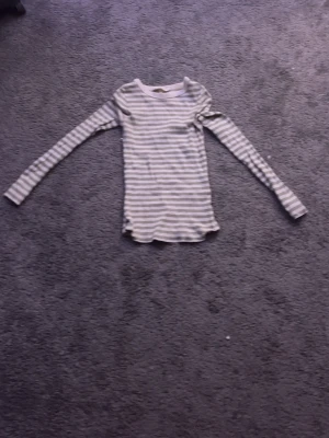 Randig långärmad tröja - Säljer en långärmad tröja med smala vita och gröna ränder. Tröjan är knappt andvänt och är helt ren ( har tvättat den också)