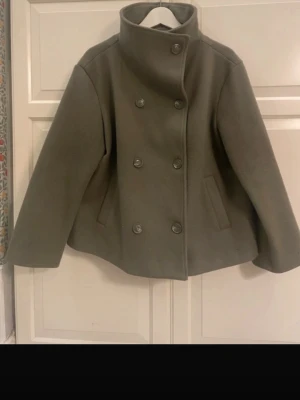 Trendig grön kappa - Säljer denna trendiga kappa från bubbleroom! Den är köpt på plick men knappt använd av mig så skicket är väldigt bra! 