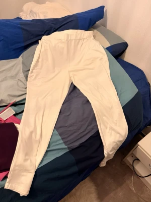 Vita mjukisbyxor med resårmidja - Säljer ett par vita mjukisbyxor med resår i midjan och smalare benslut. Perfekta för chill dagar eller när du vill ha det extra bekvämt. Tillverkade i mjukt material som känns skönt mot huden.