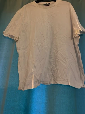 Vit basic t-shirt  - Enkel vit t-shirt med rund hals och korta ärmar. Modellen är rak och klassisk, perfekt att matcha med jeans eller shorts. 