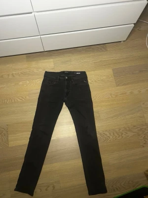 Gråa replay anbass - Säljer ett par feta replay anbass jeans i färgen grå/svart som är högt eftertraktade och trendiga. Dom är knappast använda och väldigt stilrena! Hör av er vid intresse.
